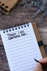 Today I am grateful for, handwritten text in notebook. Gratitude and thanksgiving list. Top view.