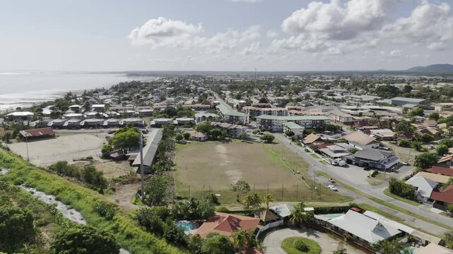 Drone flies to the left over forest and beach at low tide with reflection of clouds in the sky on the water in Kourou, French Guiana, France