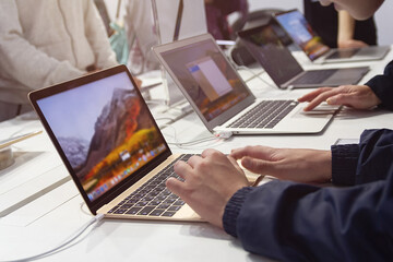 Customers select a laptop in an electronics store