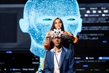 Portrait of neuroscientist doing demonstration at AI convention gathering tech startups and academics, showing how to use EEG headset to link brain with artificial intelligence