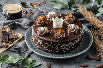 Layer Chocolate biscuit cake with cream on dark stone background with plants and nuts. Sweets, dessert and pastry, top view, close up