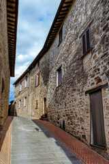 The narrow alleyways of Collemancio reveal beautifully preserved medieval architecture set against the backdrop of a clear blue sky in Umbria. Village Collemancio - Italian national heritage