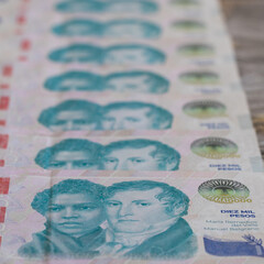 ten thousand Argentinean peso banknotes aligned, with selective focus.