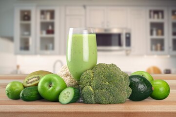 Green detox cocktail with fresh vegetables in the kitchen.