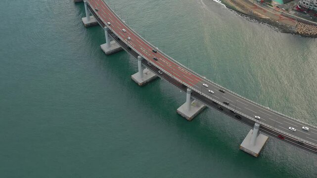 BUSAN, SOUTH KOREA - OCTOBER 19, 2024: Aerial view of the scenic bridge linking the coast with bustling city traffic