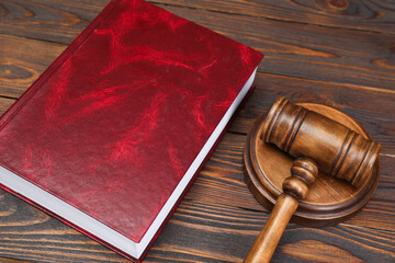Book and judge's gavel on wooden table