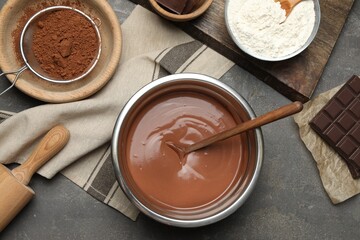 Chocolate dough in bowl and ingredients on grey table, flat lay