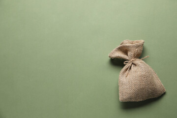 One burlap sack on olive background, top view. Space for text