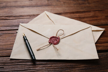 Old letter envelopes and pen on wooden table, closeup