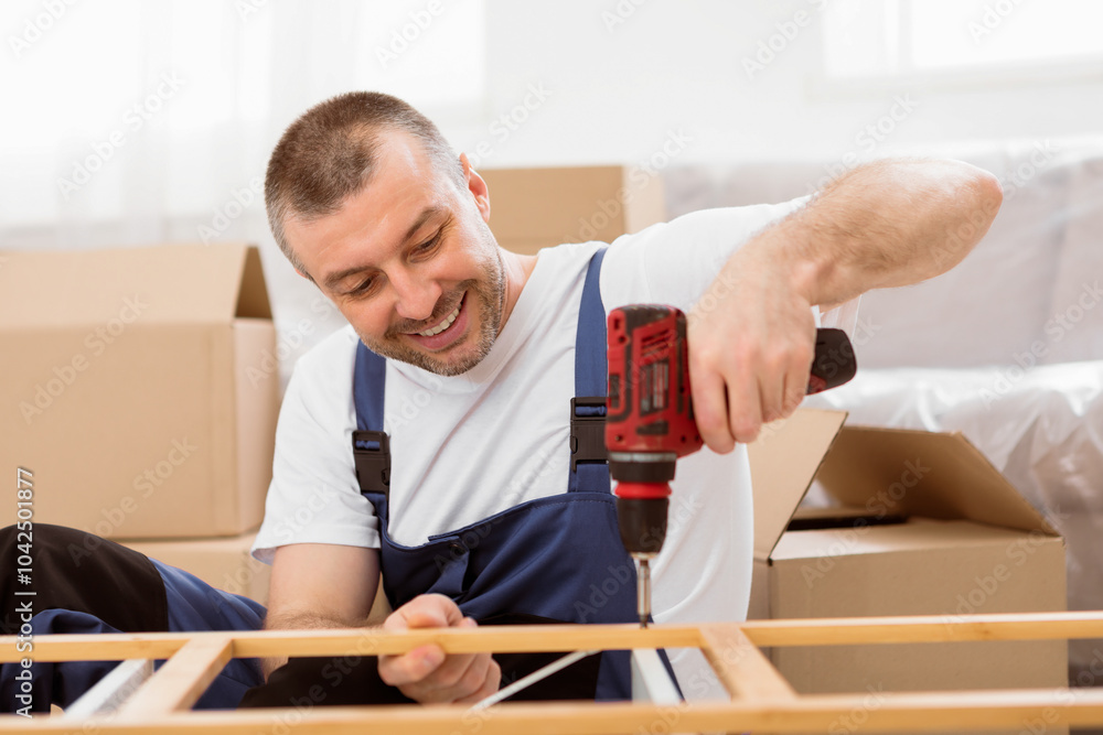 Poster furniture assembly. workman in blue uniform installing shelf using electric drill working indoor. se