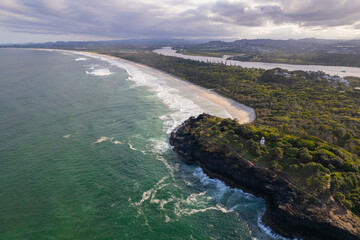Aerial views of Fingal Head Lighthouse with the causeway rock formations below in Fingal Head, New South Wales, Australia