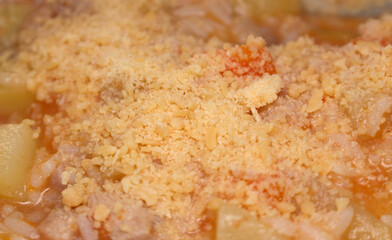 grated cheese over chicken soup. meal details food with selective focus. food background.