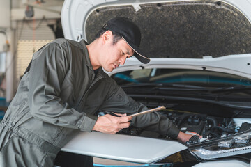 自動車のエンジンルームをチェックする自動車整備士・受け入れ検査（車検・定期点検）
