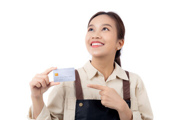 Portrait happiness young asian woman wearing apron holding and pointing credit card isolated white background, barista or waitress showing debit card for purchase or shopping online and payment.