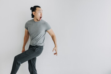 Unexpected surprise face Asian man walking and turn on isolated background. Full body.