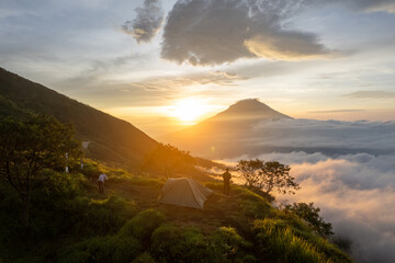 Campers witness a breathtaking sunrise over Mount Kembang, Indonesia, as they enjoy the peaceful atmosphere of the highlands. © Arif