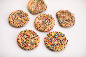 sprinkle covered cookies on white background