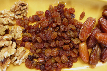 A colorful assortment of Mixed Nuts and Dried Fruits elegantly arranged on a vibrant Yellow Plate