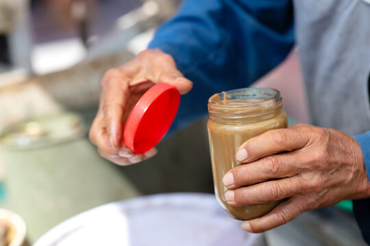 A vendor selling sesame paste is beating sesame paste