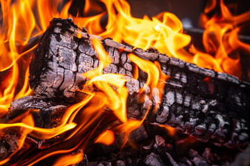Close up of fire with orange red flames burning in darkness. Coal fire