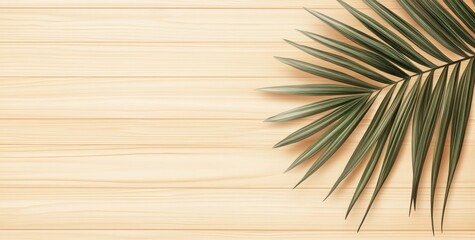 Fototapeta premium A palm leaf rests on a light wooden background, creating a tropical and serene atmosphere.