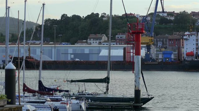 Static shot from San Juan across Pasaia bay, capturing port cranes and maritime elements. Basque Country.