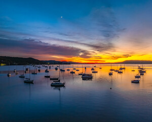 Fototapeta premium Aerial sunrise waterscape with boats and high cloud