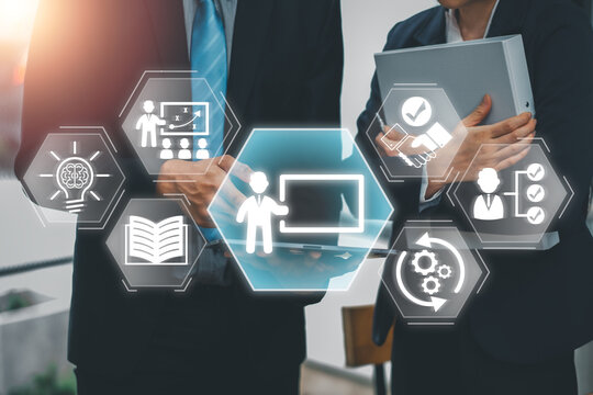 Business professionals collaborating on capacity building with digital training icons and technology.