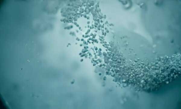 Zoom shot with micro-particle behavior in a shear flow: The camera starts with a view of micro-particles in a shear flow. The camera zooms in to show how shear forces affect particle orientation and i