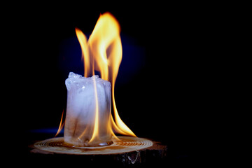 ice cube burning in fire isolated on black background with copy space