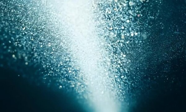 Pan shot with dynamic shadows: The camera starts with a close-up of micro-particles illuminated by a moving light source. The camera pans horizontally to capture the dynamic shadows created by the par
