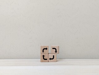 Wooden blocks with directional arrows, symbolizing a cyclical process.