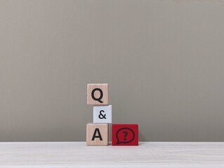 wooden cube with the letter Q & A and question mark icon. education