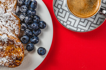 French toast on a white plate with blueberries and coffee for breakfast