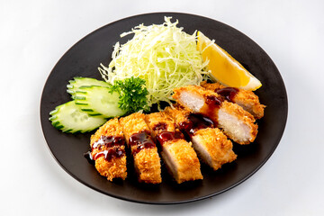 Japanese pork cutlet and shredded cabbage on a black plate