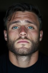 Fototapeta premium Intense Portrait of a Young Man with Striking Blue Eyes and a Full Beard