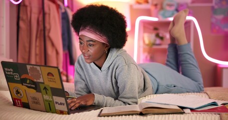Black girl, laptop and learning in home for university, online course and research project with video at night. Student, technology and study on bed for college, education and exam notes with book