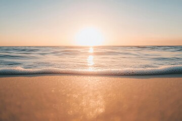 A close-up of foamy waves on a beach with the sun setting in the background.