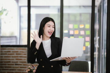 Beautiful Asian businesswoman working on laptop in office