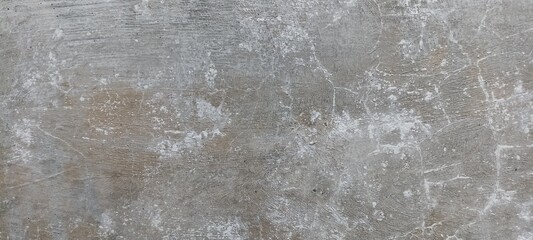 Obraz premium Distressed Concrete Surface with Scratches and Wear Marks Texture. A rough, distressed concrete surface showing wear and scratches, perfect for industrial backgrounds