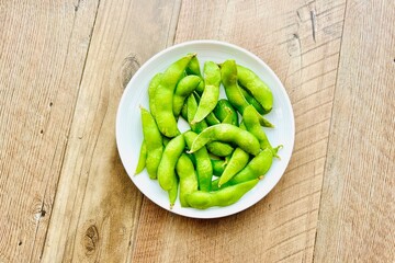 木目のダイニングテーブルと枝豆のおつまみ