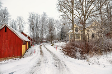 Icy winter road by a farm in the countryside
