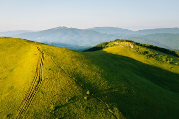 Gorgeous green meadows stretched along the mountain range on a sunny day. Carpathian mountains,...