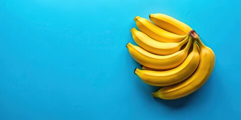 Flat lay of yellow bananas on blue background with selective focus