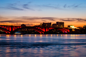 Communal bridge over the Yenisei River at night with beautiful lighting and reflection in the water