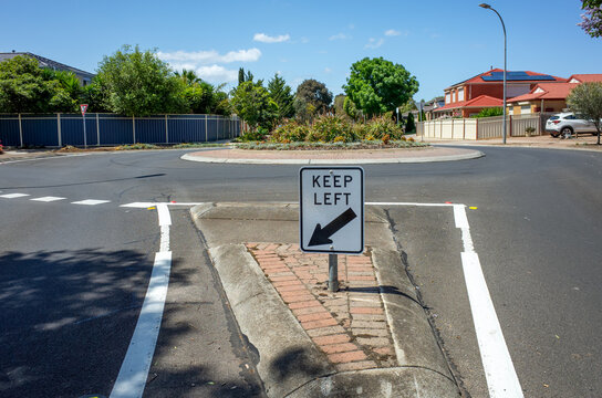 A 'Keep Left' sign is displayed at the entrance of the roundabout, directing drivers to stay in the left lane on an Australian suburban street.
