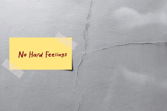 Stick note on cracked wall with text written NO HARD FEELINGS - making agreement with someone not to be angry, upset, or bitter about something