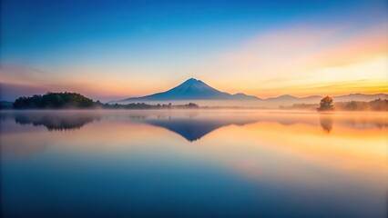 Landscape of river with fog on water surface and distant mountain at twilight symmetric reflection and pastel colors