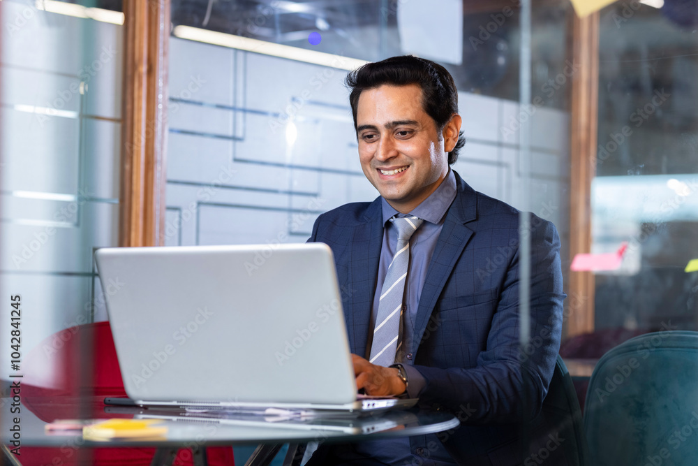 Wall mural successful businessman in modern office working on laptop