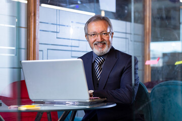 Senior software developer working on a laptop in an office